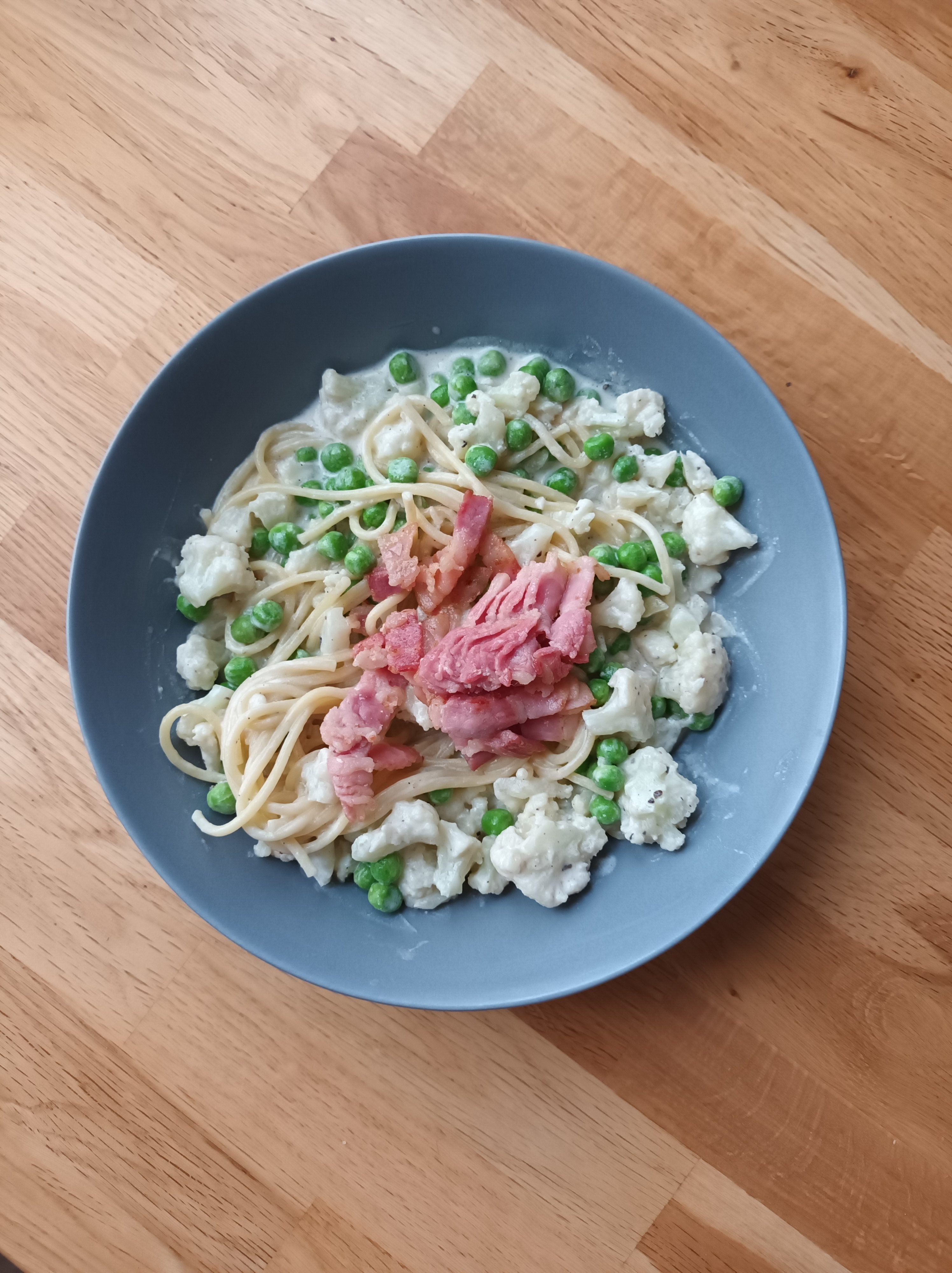 Pasta med blomkålssås, gröna ärtor och bacon